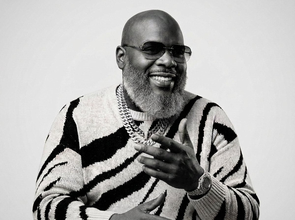 Black and white portrait of Tom Swoope smiling in sunglasses and a striped sweater